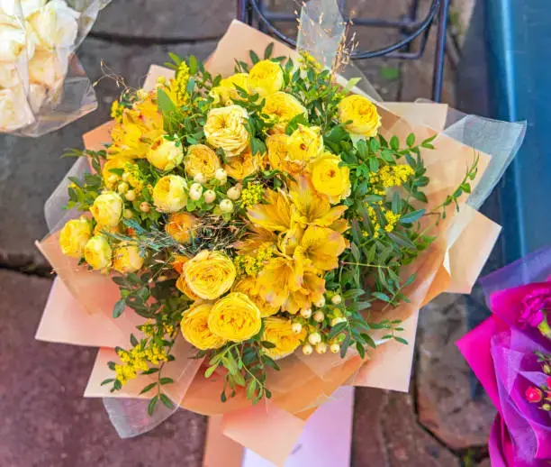 Bright yellow rose bouquet with greenery, beautifully wrapped in paper, perfect for gifting and floral decor in the UAE. Flowers UAE.