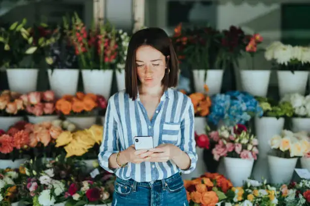 Customer making online booking at flower shop in Fujairah surrounded by fresh flowers