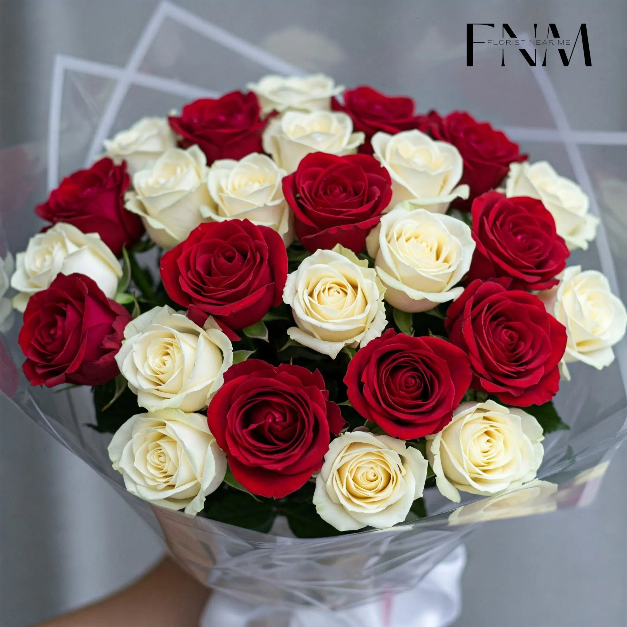 Elegant bouquet of red roses wrapped in black paper with golden ribbon