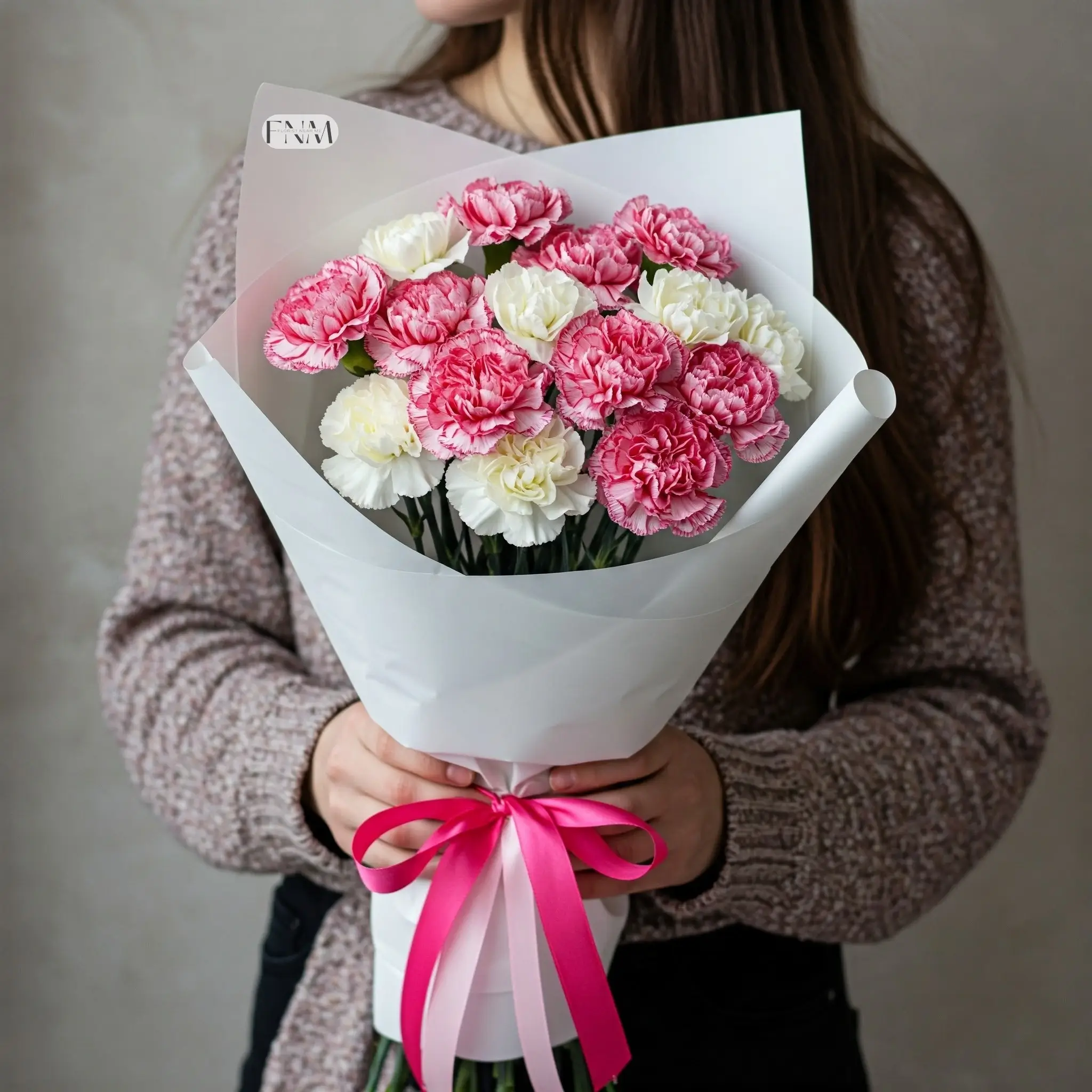 Elegant bouquet of pink and white carnations wrapped in soft paper for gifting